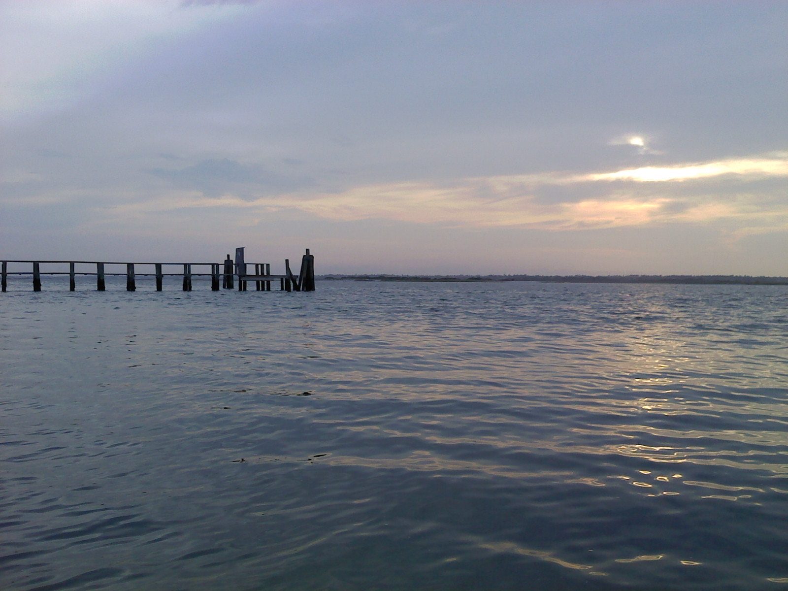 Calm sound water at dusk on Topsail Island, with an old dock in silhouette